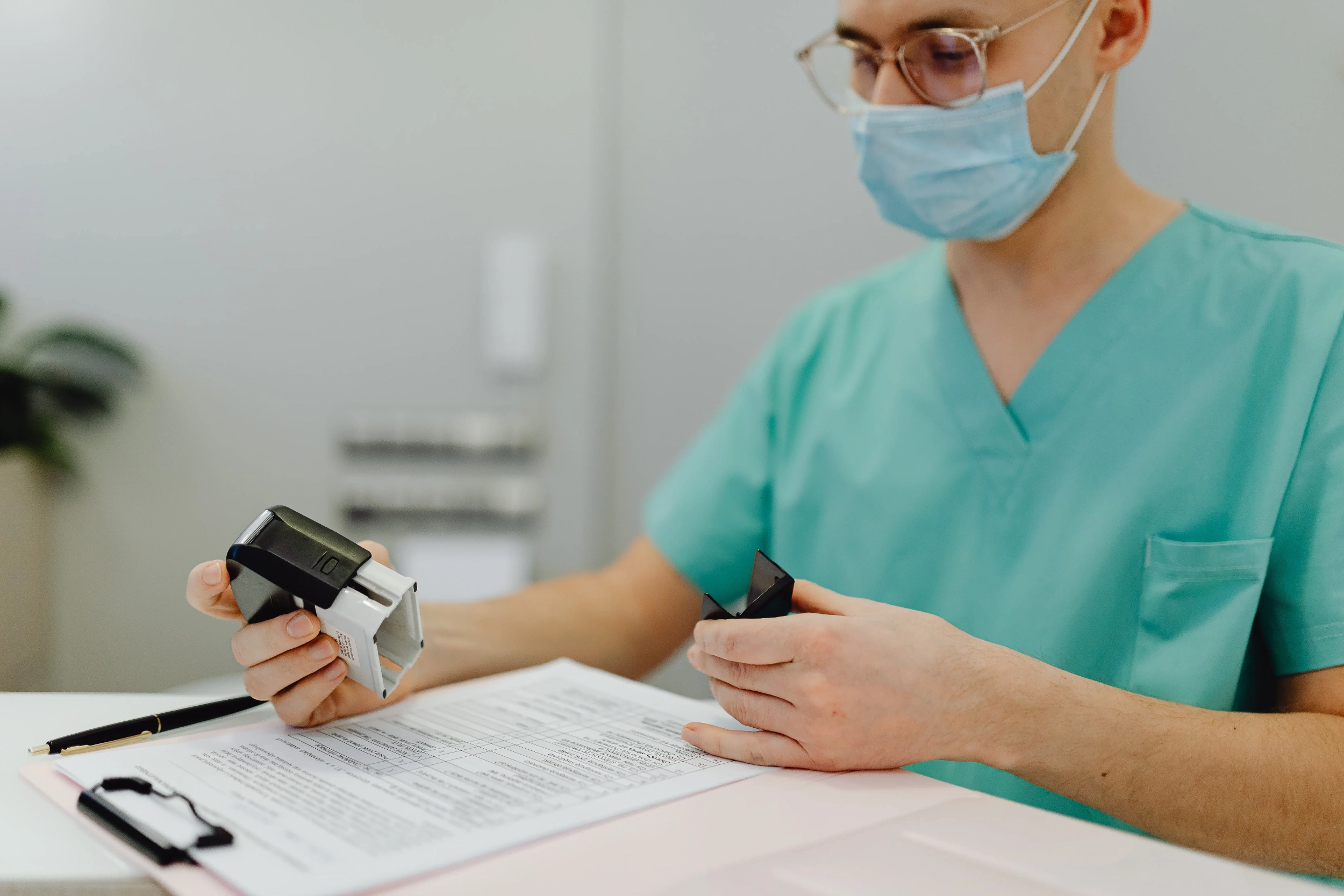 Pracownik placówki udzielającej świadczeń zdrowotnych przeglądający dokumentację potrzebną do uzyskania akredytacji przez szpital.
