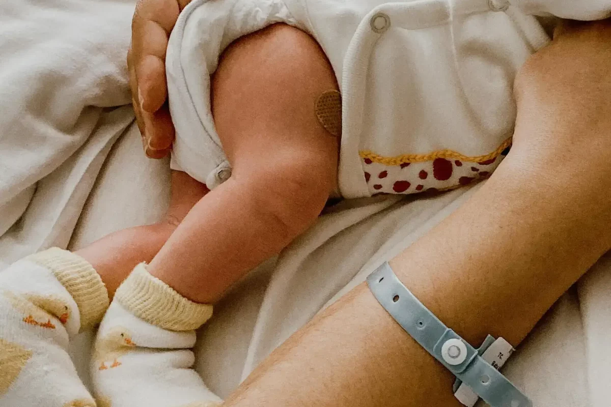 Matka leżąca z dzieckiem w łóżku szpitalnym.