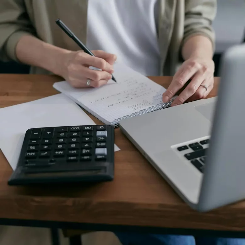 Laptop, kalkulator i notes osoby wnoszącej majątek przedsiębiorstwa do fundacji rodzinnej.