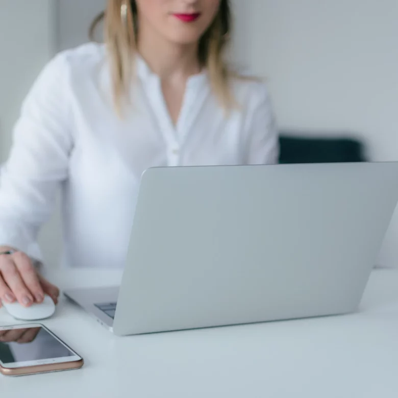Kobieta przed laptopem sprawdza, jak założyć spółkę z ograniczoną odpowiedzialnością przez Internet.