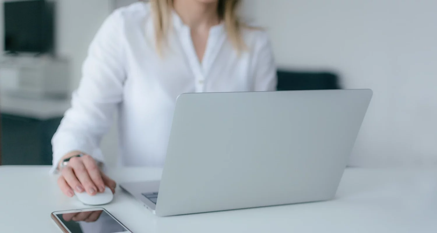 Kobieta przed laptopem sprawdza, jak założyć spółkę z ograniczoną odpowiedzialnością przez Internet.