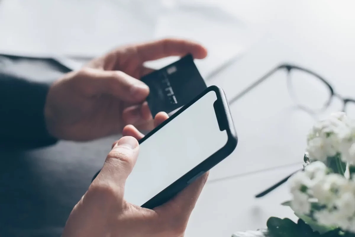 Mężczyzna przepisujące dane z karty kredytowej do formularza na stronie internetowej.